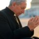 priest praying at the capitol